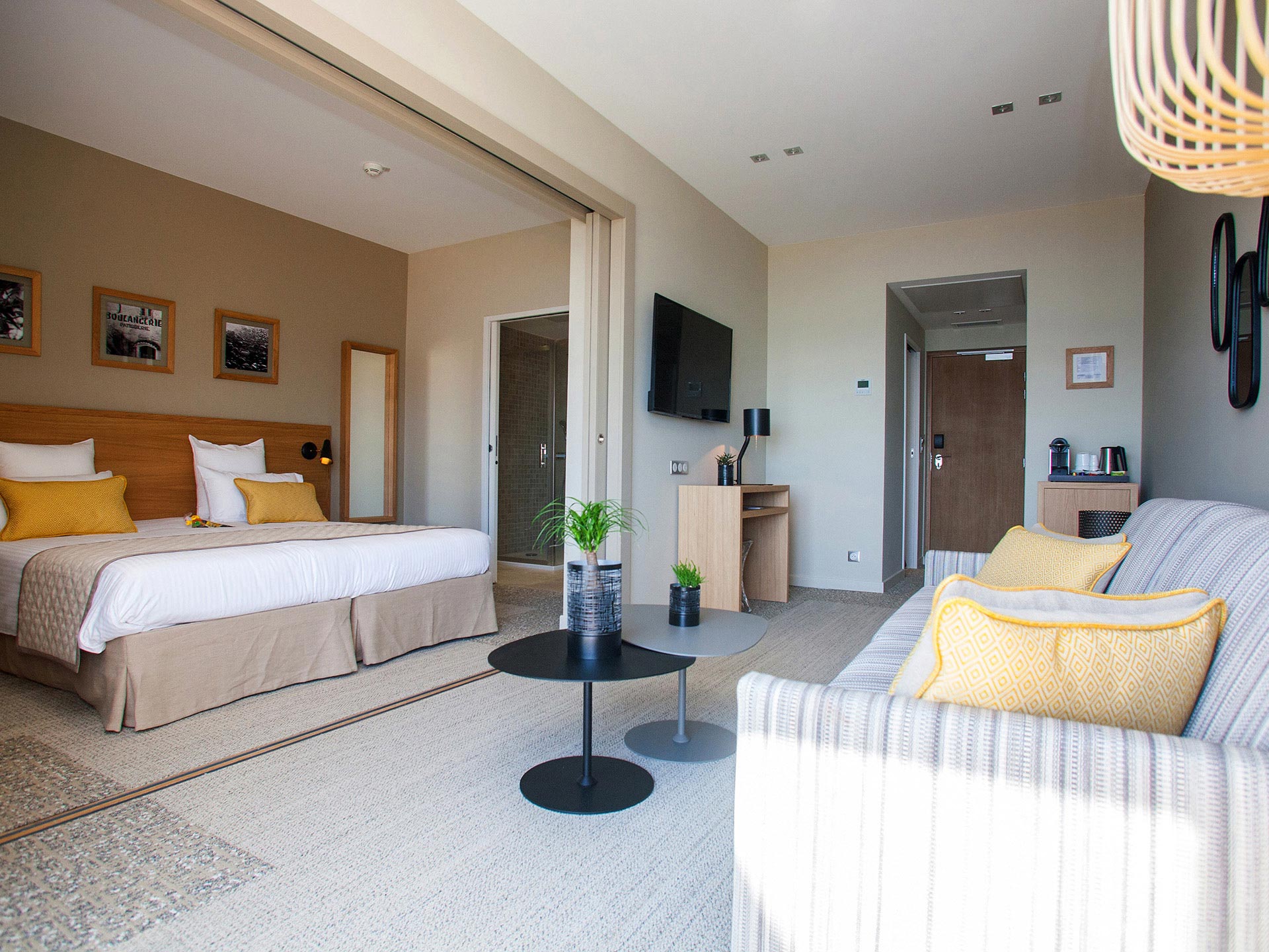Junior suite d’hôtel moderne avec lit double et coin salon