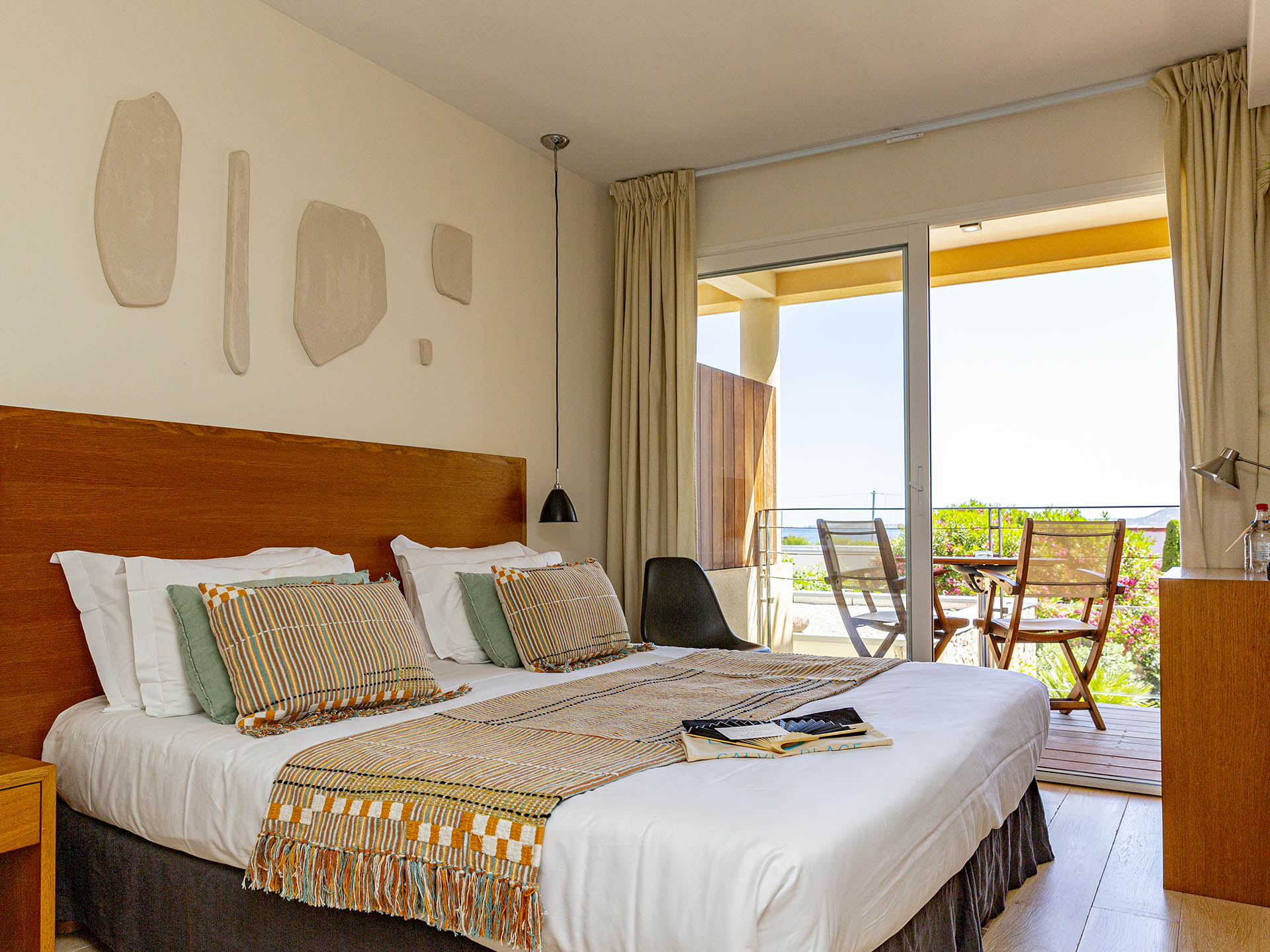 Chambre d’hôtel moderne avec lit double et balcon donnant sur la verdure
