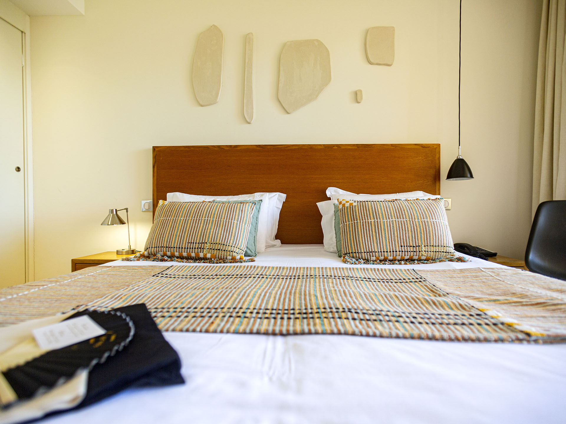 Chambre d’hôtel moderne avec lit double, décoration murale et ambiance minimaliste