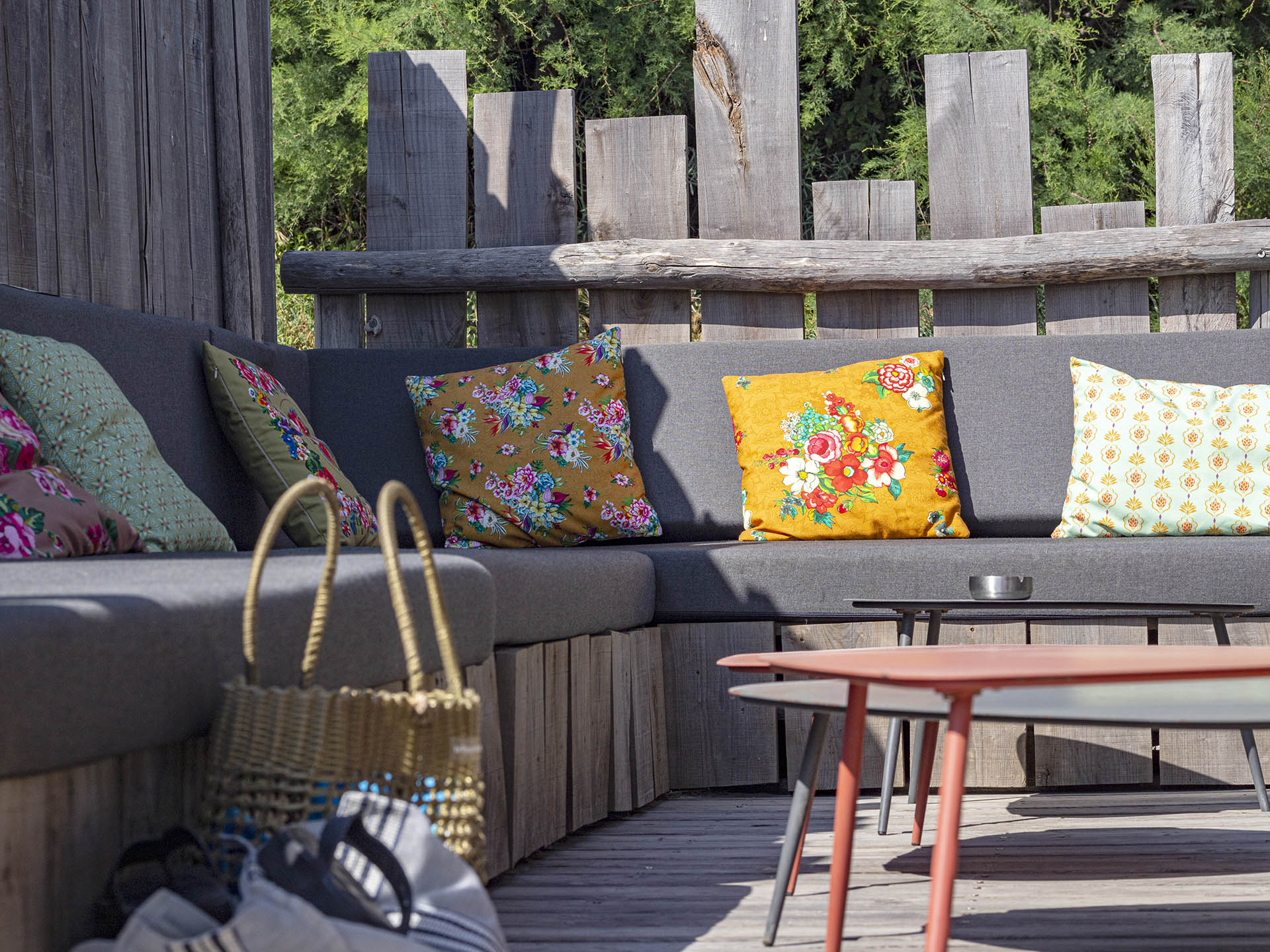 Espace lounge de Marco Plage avec canapé d’extérieur et tables basses sur terrasse en bois