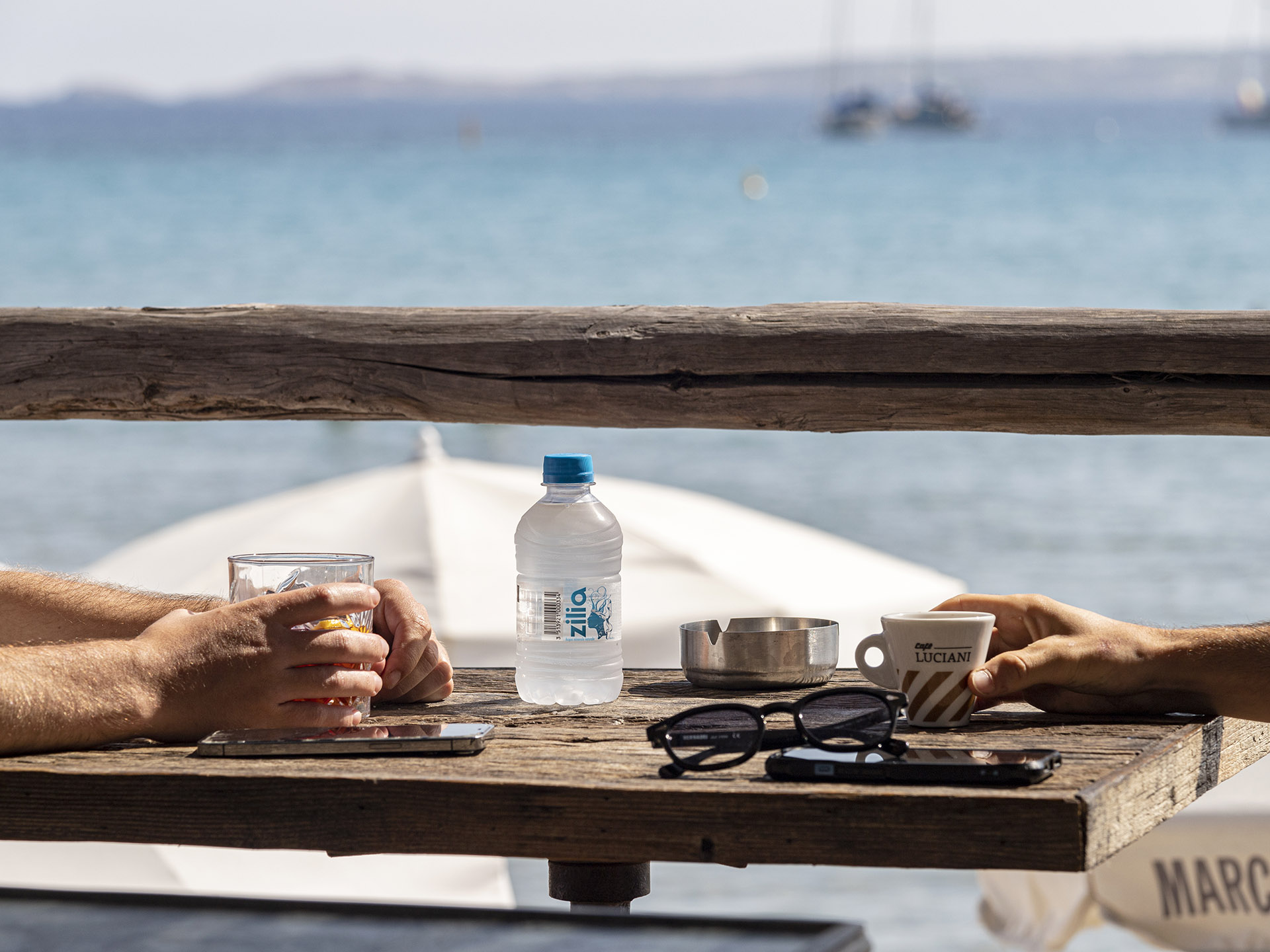 Table de Marco Plage avec boissons face à la mer et aux voiliers