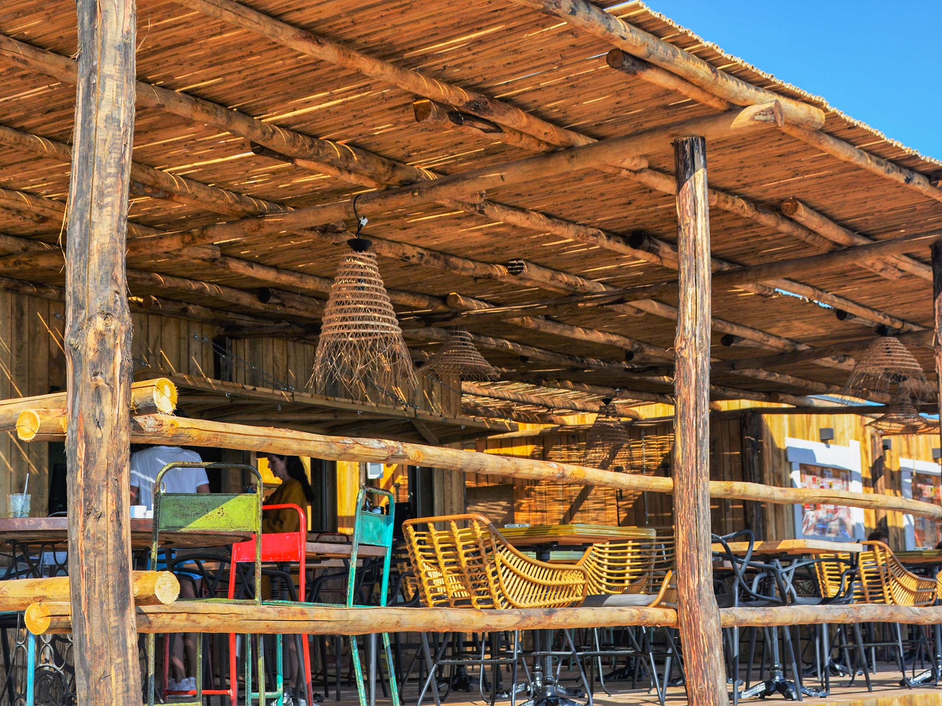 Espace restaurant de Marco Plage avec mobilier coloré sous toiture en bois